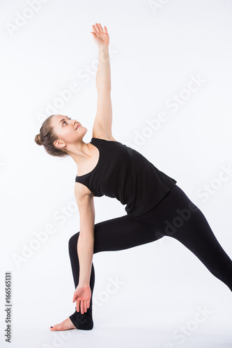 advanced yoga posture, demonstrated by bloden girl, dressed in black, on white background