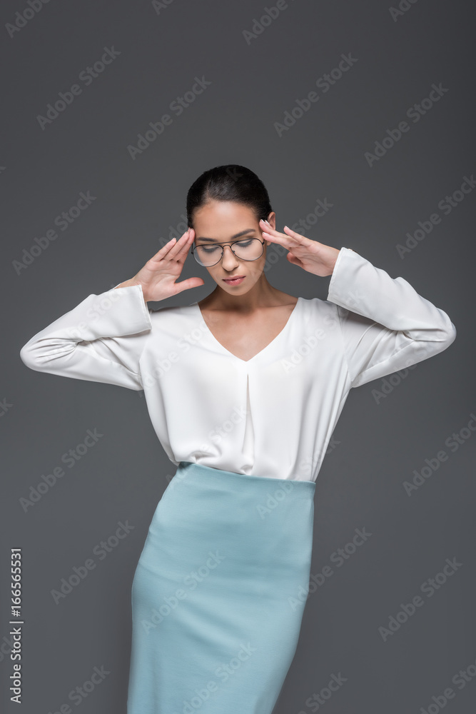beautiful stylish businesswoman posing in eyeglasses, isolated on grey