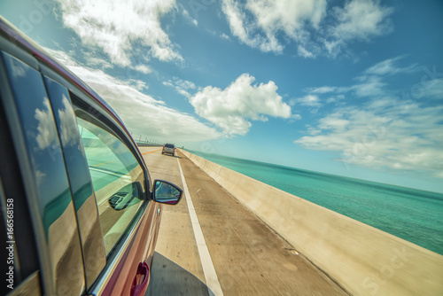 Driving machine at speed over the bridge across the beautiful emerald bay. The atmosphere of travel. USA. Florida. Road to Key West
 photo