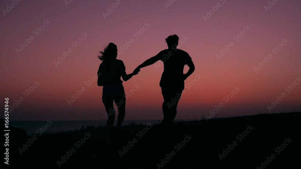 Silhouette of Young Teenage Couple in Love Running and Spinning at Beautiful Pink Sunset. HD Slowmotion Carefree Lifestyle Footage. Silhouette of Young Teenage Couple in Love Running and Spinning at Beautiful Pink Sunset. HD Slowmotion Carefree Lifestyle Footage.