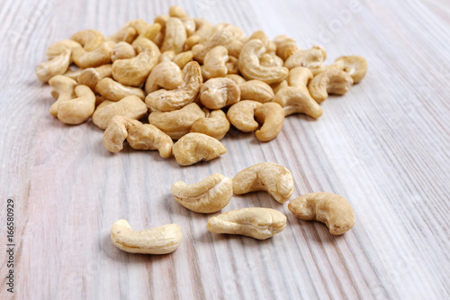A heap of cashew nuts on a light kitchen table close-up.