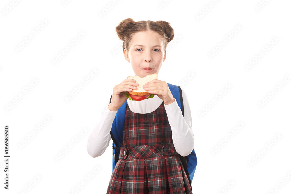Portrait of cute girl in school uniform eating sandwich against white background Portrait of cute girl in school uniform eating sandwich against white background