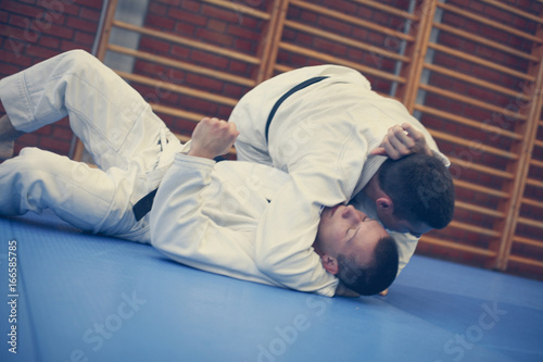 Two young males practicing judo together. © liderina