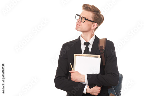 Studio portrait of teenage college student in black suit posing against white background