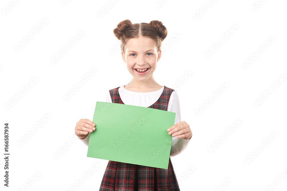 Portrait of happy girl in school uniform holding blank paper against white background Portrait of happy girl in school uniform holding blank paper against white background