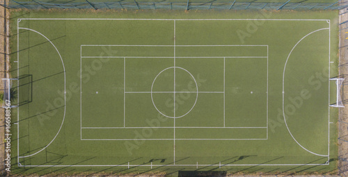 Vista aerea perpendicolare di un campo da calcio a 5 in erba sintetica. SI tratta di un campo polifunzionale.. A bordo campo panchine e ombrelli. I campi sono vuoti perchè è estate e fa caldo. photo