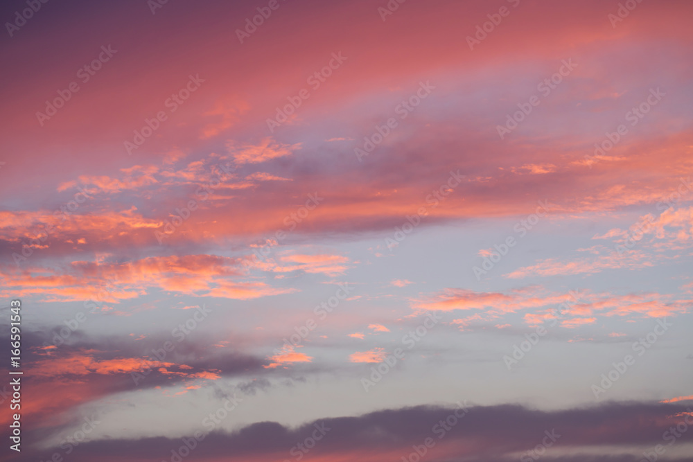 Sunset sky with orange and blue colored clouds.