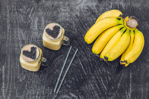 Banana smoothies and bananas on an old wooden background photo