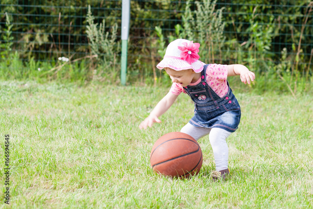 girl plays with basketball ball in the garden girl plays with basketball ball in the garden