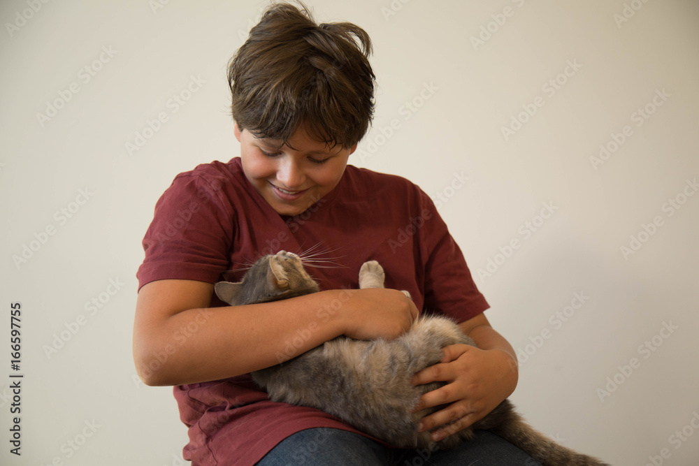 Cute caucasian teen hugging grey cat indoor isolated Cute caucasian teen hugging grey cat indoor isolated