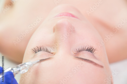Beautiful young woman gets beauty injection in eye area