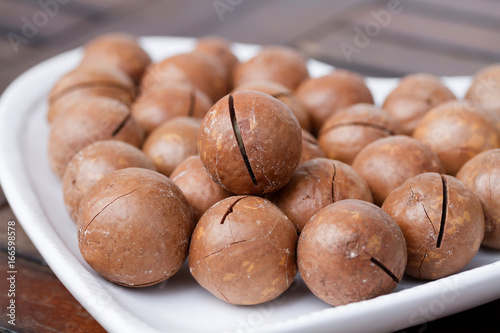 Macadamia nuts on the wooden background