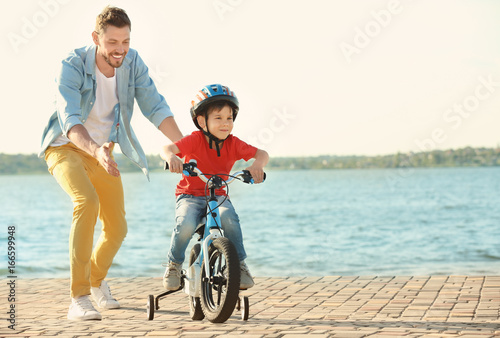 Young man teaching his son ...