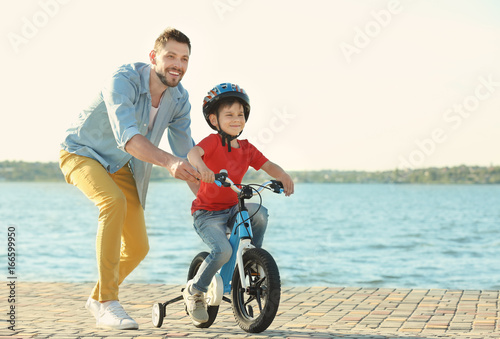 Young man teaching his son ...