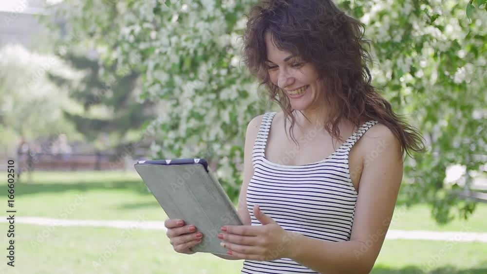 girl with tablet in the Park. communicating on the Internet girl with tablet in the Park. communicating on the Internet
