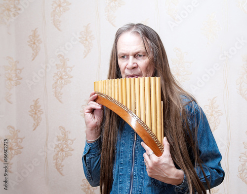 Portrait of a man playing the pan flute photo