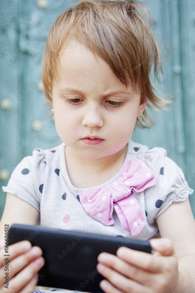 Social Media addiction. beautiful baby girl holding phone (psychological problems, media mania, education) Social Media addiction. beautiful baby girl holding phone (psychological problems, media mania, education)