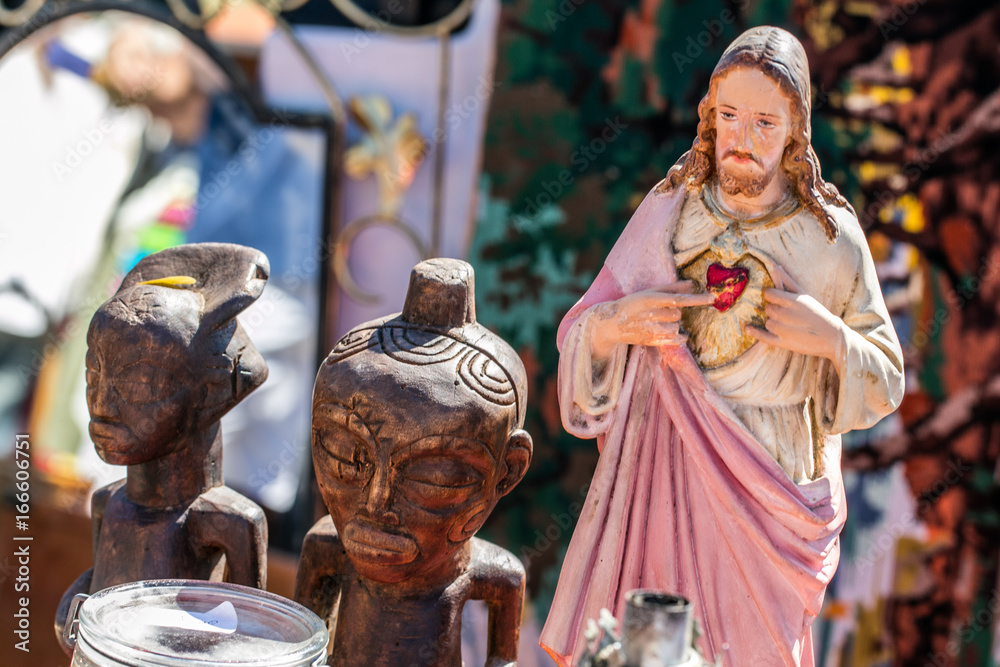 polytheism religion symbols, Christ and wooden African statues at garage sale