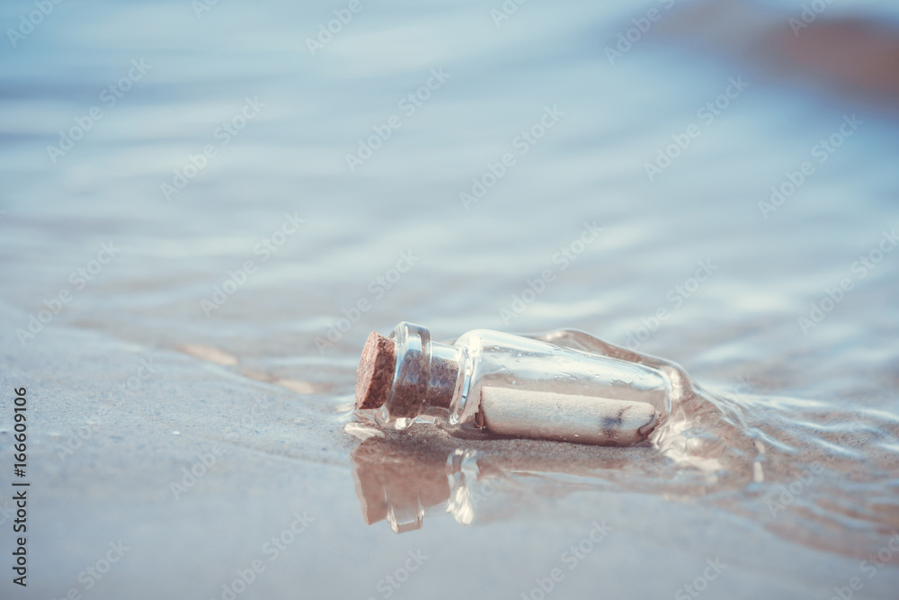 Message in the bottle washed out from sea against the sun setting down Message in the bottle washed out from sea against the sun setting down
