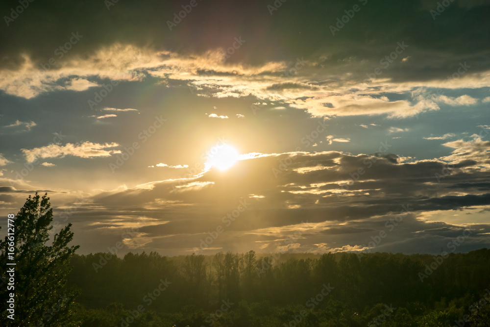 Cloudy sky at sunset over the forest.