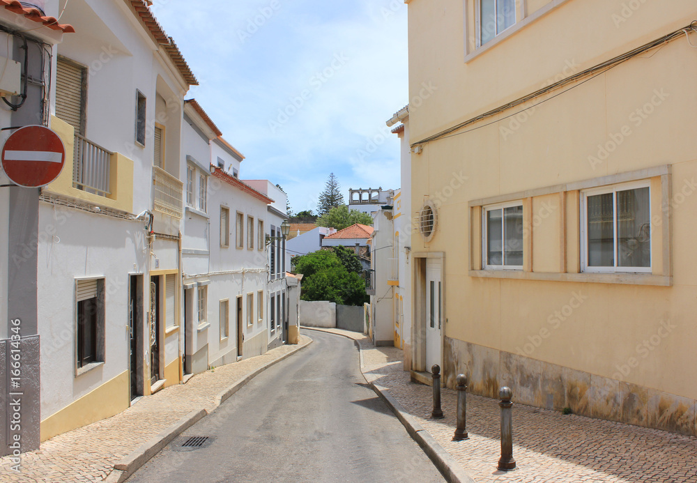 Typical european touristic small town street in Lagos Algarve coast, Portugal. Traditional historic old city architecture, residential area, lifestyle theme, summer scene with stop sign and empty road
