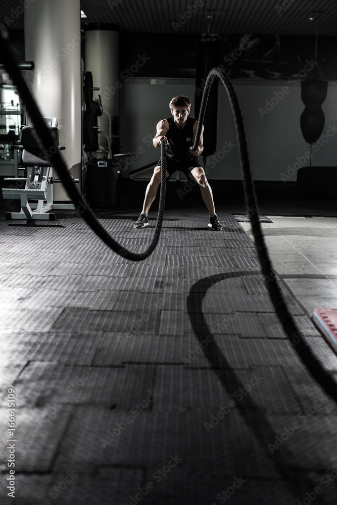 Crossfit battling ropes at gym workout exercise. Crossfit