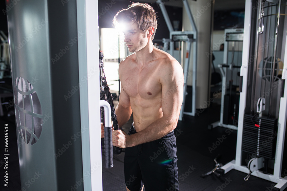 Man doing cable fly exercise in gym. Young athletic man. Man doing cable fly exercise in gym. Young athletic man.