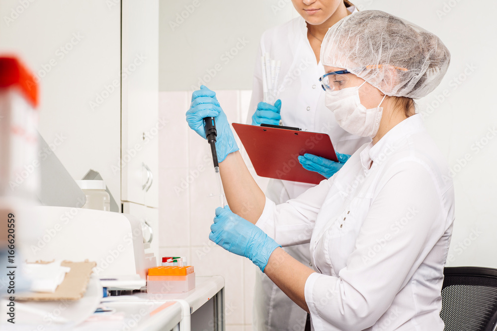 Focused young life researcher with pipette. Focused young life researcher with pipette.