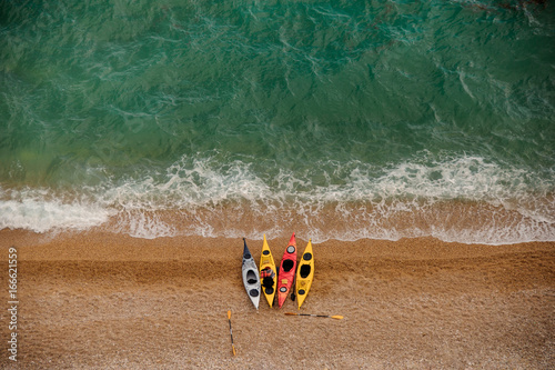 Colorful kayaks on sandy beach. Aquasport.