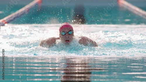 Female Athlete Swimming Butterfly Stroke In The Pool Towards Camera