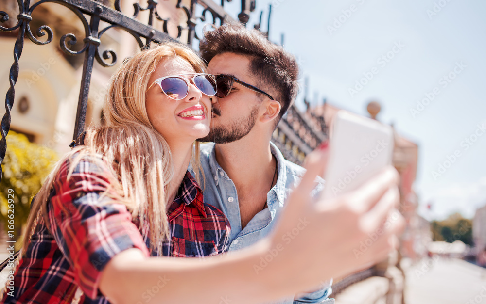 Young smiling couple taking a selfie with smart phone. Love and tenderness. Dating, lifestyle concept