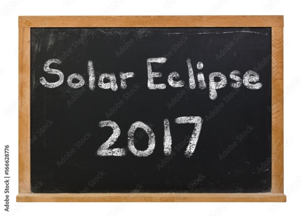 Solar Eclipse 2017 written in white chalk on a black chalkboard isolated on white Solar Eclipse 2017 written in white chalk on a black chalkboard isolated on white
