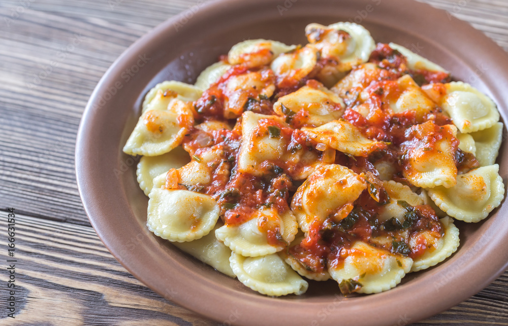 Portion of ravioli with marinara sauce Portion of ravioli with marinara sauce