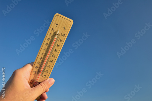 фотографія Mercury wooden thermometer shows very high temperature