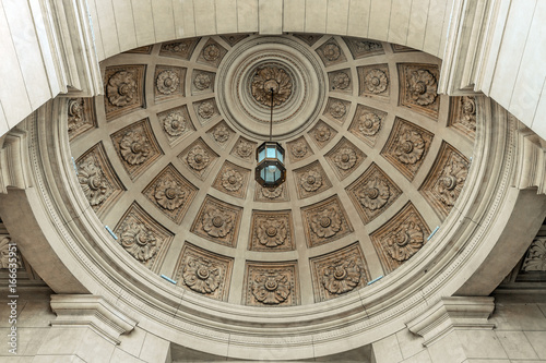 Vaulted ceiling with central lamp in a neoclassical building seen from below photo