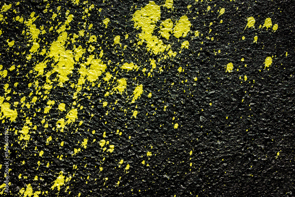 Yellow paint spray splash on black concrete wall background. Yellow paint spray splash on black concrete wall background.