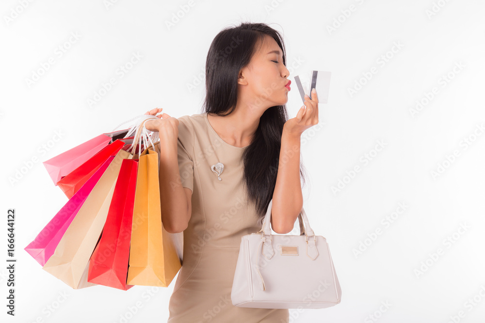 Happy Asian woman smile with shopping bags and looking in credit card,Isolated on white background Happy Asian woman smile with shopping bags and looking in credit card,Isolated on white background