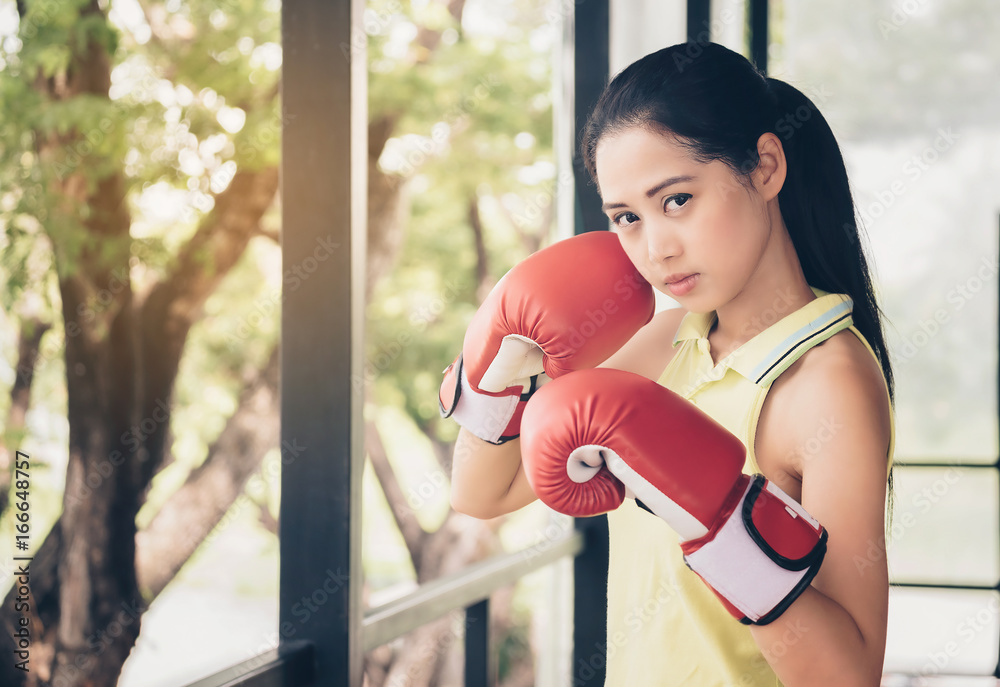 Asian cute girl boxer wearing gloves boxer, sparring with determination and seriousness.