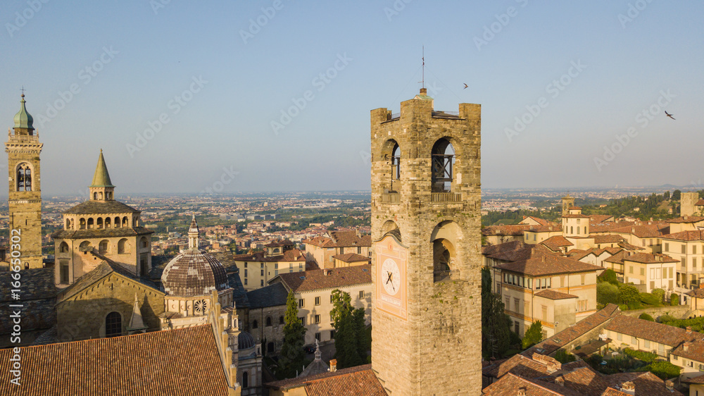 Bergamo, old city, drone aerial view of the Basilica of Santa Maria Maggiore and the bell tower. On the background the Padana plain