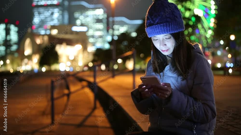 Woman use of smart phone in Yokohama city at night Woman use of smart phone in Yokohama city at night