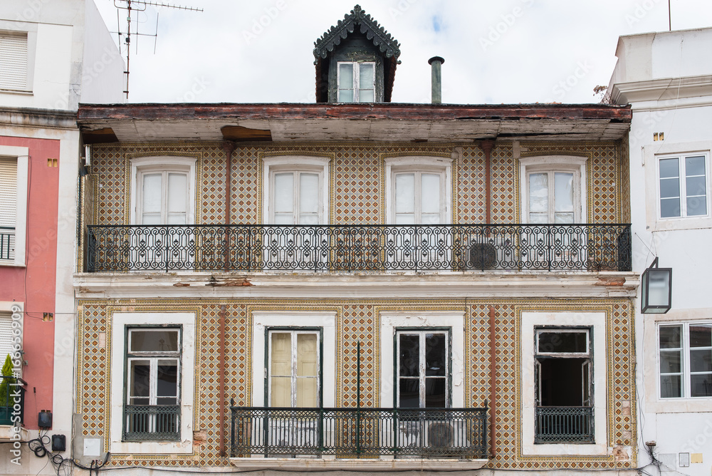 Portugal, typical facade with brown azulejos and balcony

