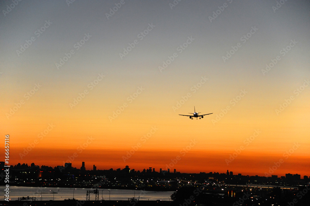 airplane on the colorful sunset sky in New York