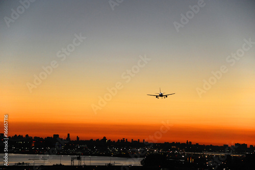 airplane on the colorful sunset sky in New York