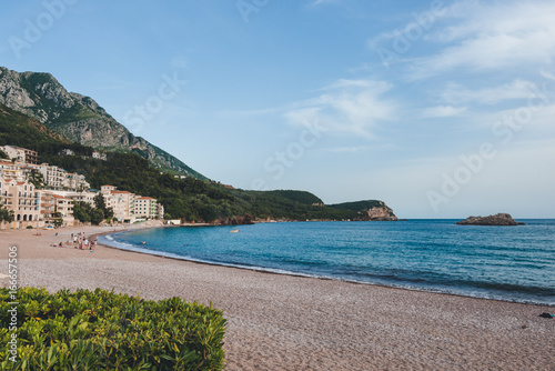 Public beach near Sveti Stefan island, Montenegro. Pebble beach and coastline with resorts near Budva.
