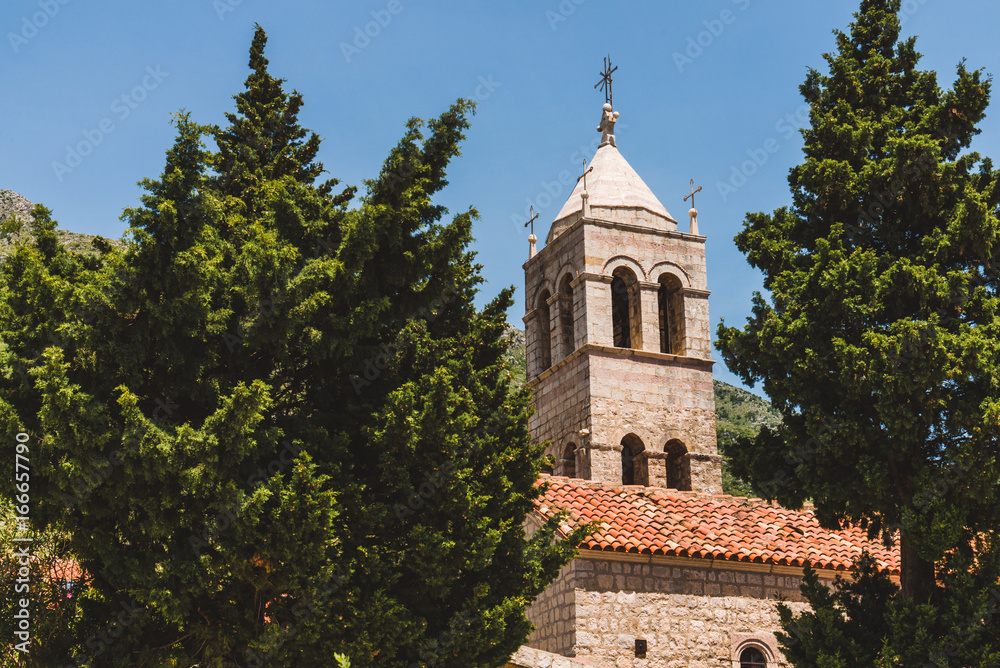 Rezevici abbey is situated between Budva and Petrovac, Montenegro.Stone belfry and facade of The Serbian Orthodox Rezevici Monastery located in Katun Rezevici village near Perazica Do.