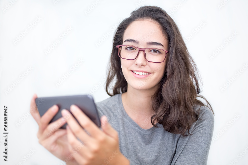 Fototapeta premium Positive young woman in glasses holding smartphone