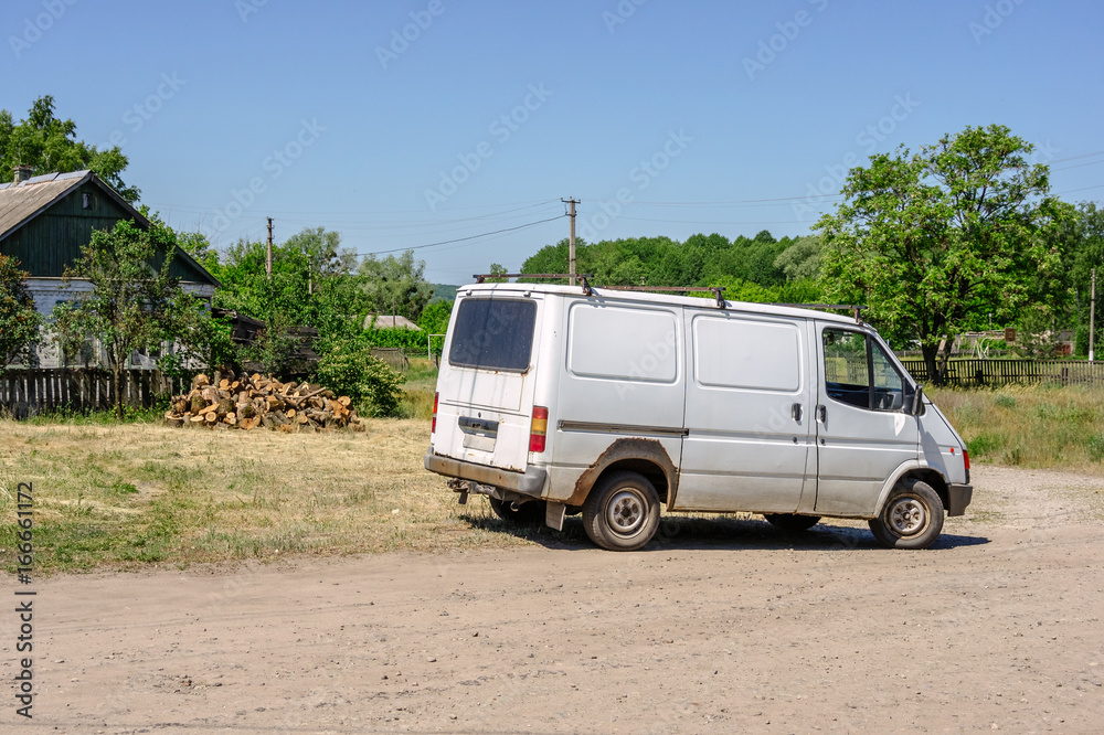 Old white van in the village in summer