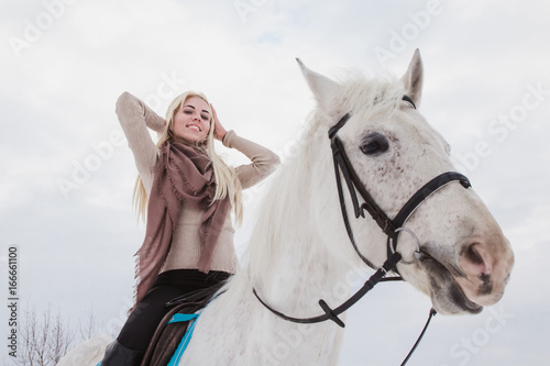 Nice girl and white horse outdoor in a winter