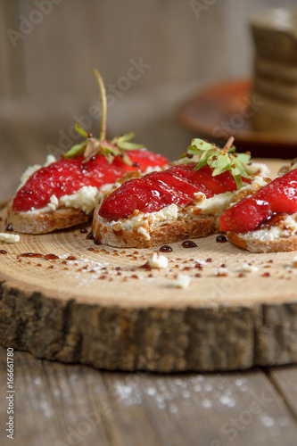 Fruit brusquest with raspberry and cottage cheese on a wooden board photo