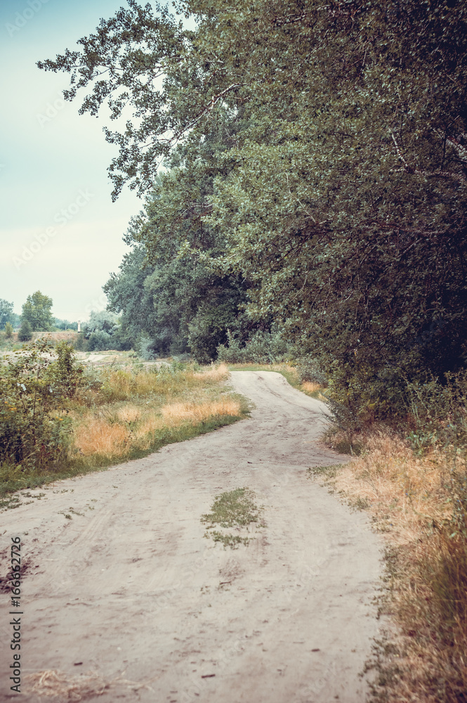 Old rural road in summertime. Style toned photo. Old rural road in summertime. Style toned photo.